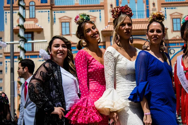 Seville, İspanya - 1 Mayıs 2022 Sevilla 'lılar geleneksel Endülüs tarzında giyinmiş Feria de Seville koridorlarında dolaşıyorlar.