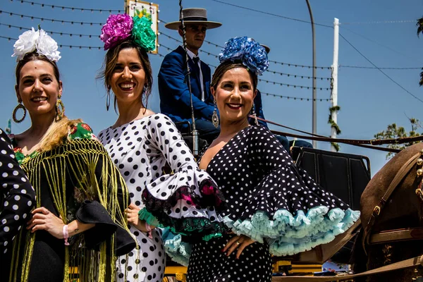 Seville, İspanya - 1 Mayıs 2022 Sevilla 'lılar geleneksel Endülüs tarzında giyinmiş Feria de Seville koridorlarında dolaşıyorlar.