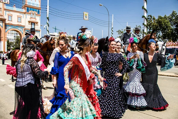 Seville, İspanya - 1 Mayıs 2022 Sevilla 'lılar geleneksel Endülüs tarzında giyinmiş Feria de Seville koridorlarında dolaşıyorlar.