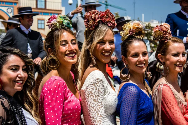 Seville, İspanya - 1 Mayıs 2022 Sevilla 'lılar geleneksel Endülüs tarzında giyinmiş Feria de Seville koridorlarında dolaşıyorlar.