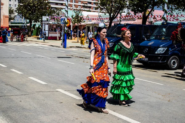 Seville, İspanya - 1 Mayıs 2022 Sevilla 'lılar geleneksel Endülüs tarzında giyinmiş Feria de Seville koridorlarında dolaşıyorlar.