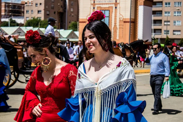 Seville, İspanya - 1 Mayıs 2022 Sevilla 'lılar geleneksel Endülüs tarzında giyinmiş Feria de Seville koridorlarında dolaşıyorlar.