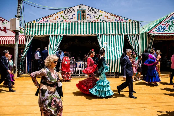 Seville, İspanya - 1 Mayıs 2022 Sevilla 'lılar geleneksel Endülüs tarzında giyinmiş Feria de Seville koridorlarında dolaşıyorlar.