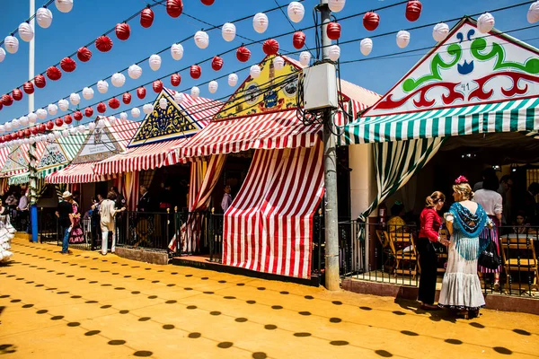 Seville, İspanya - 1 Mayıs 2022 Sevilla 'lılar geleneksel Endülüs tarzında giyinmiş Feria de Seville koridorlarında dolaşıyorlar.