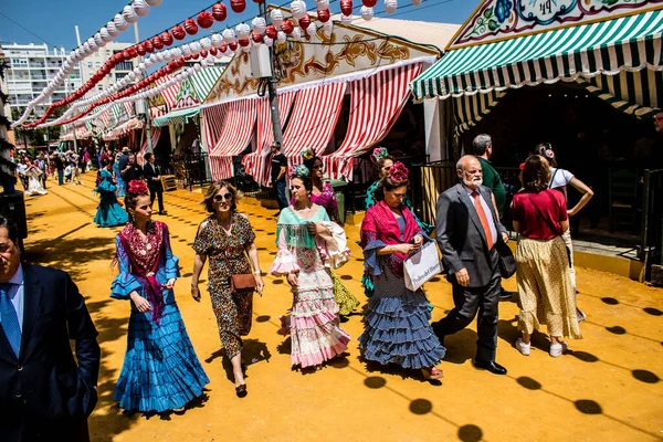 Seville, İspanya - 1 Mayıs 2022 Sevilla 'lılar geleneksel Endülüs tarzında giyinmiş Feria de Seville koridorlarında dolaşıyorlar.