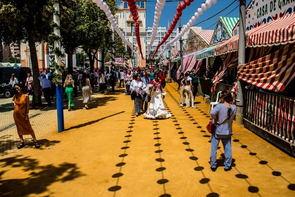 Seville, İspanya - 1 Mayıs 2022 Sevilla 'lılar geleneksel Endülüs tarzında giyinmiş Feria de Seville koridorlarında dolaşıyorlar.