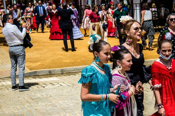 Seville, İspanya - 1 Mayıs 2022 Sevilla 'lılar geleneksel Endülüs tarzında giyinmiş Feria de Seville koridorlarında dolaşıyorlar.
