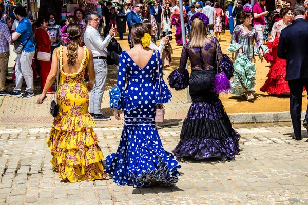 Seville, İspanya - 1 Mayıs 2022 Sevilla 'lılar geleneksel Endülüs tarzında giyinmiş Feria de Seville koridorlarında dolaşıyorlar.