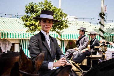 Seville, Spain - May 01, 2022 Sevillian riders dressed in the traditional Andalusian way parading through the aisles of the Feria de Seville, the most famous festival in Spain