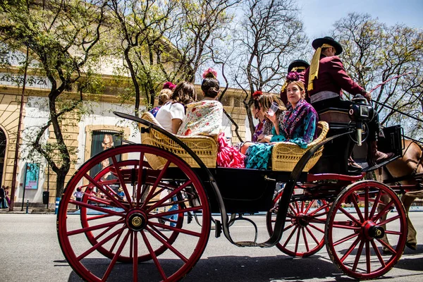 Seville, İspanya... 1 Mayıs 2022 Sevilla 'lılar geleneksel Endülüs tarzında giyinip Seville sokaklarında at arabasıyla geziyorlar.