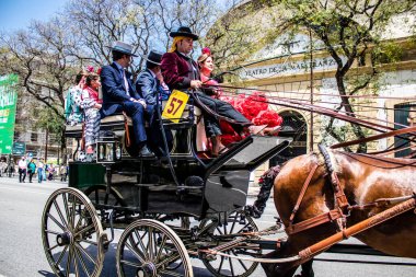 Seville, İspanya... 1 Mayıs 2022 Sevilla 'lılar geleneksel Endülüs tarzında giyinip Seville sokaklarında at arabasıyla geziyorlar.