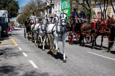 Seville, İspanya... 1 Mayıs 2022 Sevilla 'lılar geleneksel Endülüs tarzında giyinip Seville sokaklarında at arabasıyla geziyorlar.