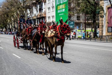 Seville, İspanya... 1 Mayıs 2022 Sevilla 'lılar geleneksel Endülüs tarzında giyinip Seville sokaklarında at arabasıyla geziyorlar.