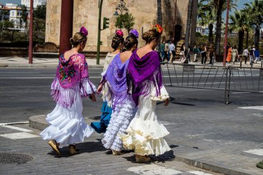 Seville, İspanya - 01 Mayıs 2022 Sevilla sokaklarında yürüyen geleneksel Endülüs tarzı giyinmiş Sevilla halkı iki yıl süren şiddetli bir salgından sonra geri döndü.