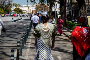 Seville, İspanya - 01 Mayıs 2022 Sevilla sokaklarında yürüyen geleneksel Endülüs tarzı giyinmiş Sevilla halkı iki yıl süren şiddetli bir salgından sonra geri döndü.