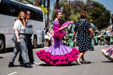Seville, İspanya - 01 Mayıs 2022 Sevilla sokaklarında yürüyen geleneksel Endülüs tarzı giyinmiş Sevilla halkı iki yıl süren şiddetli bir salgından sonra geri döndü.