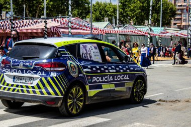 Seville, İspanya - 1 Mayıs 2022 İspanya 'nın en ünlü festivali olan Feria de Sevilla sırasında sokaklarda dolaşan polis arabası iki yıl süren Covid salgınından sonra geri döndü.