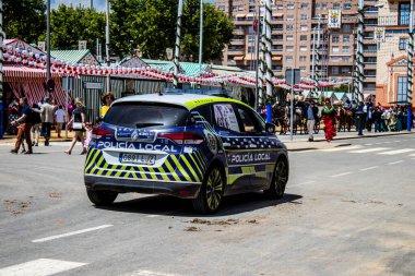 Seville, İspanya - 1 Mayıs 2022 İspanya 'nın en ünlü festivali olan Feria de Sevilla sırasında sokaklarda dolaşan polis arabası iki yıl süren Covid salgınından sonra geri döndü.