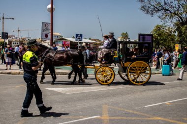 Seville, İspanya - 01 Mayıs 2022 İspanya 'nın en ünlü festivali olan Feria de Sevilla sırasında sokaklara düşen polis memuru, iki yıl süren şiddetli bir salgından sonra kutlamaya geri döndü.