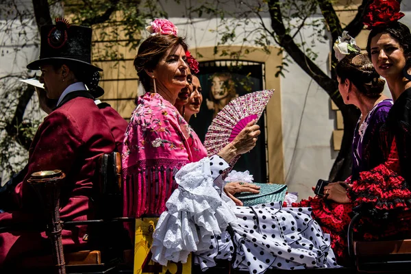 Seville, İspanya... 1 Mayıs 2022 Sevilla 'lılar geleneksel Endülüs tarzında giyinip Seville sokaklarında at arabasıyla geziyorlar.