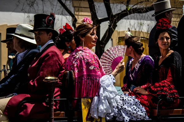 Seville, İspanya... 1 Mayıs 2022 Sevilla 'lılar geleneksel Endülüs tarzında giyinip Seville sokaklarında at arabasıyla geziyorlar.