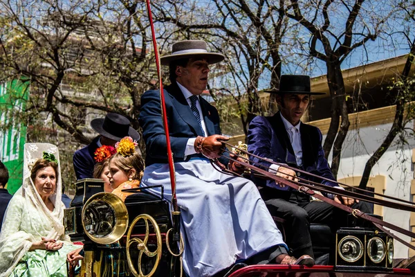 Seville, İspanya... 1 Mayıs 2022 Sevilla 'lılar geleneksel Endülüs tarzında giyinip Seville sokaklarında at arabasıyla geziyorlar.