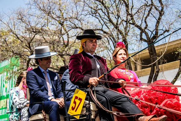 Seville, İspanya... 1 Mayıs 2022 Sevilla 'lılar geleneksel Endülüs tarzında giyinip Seville sokaklarında at arabasıyla geziyorlar.