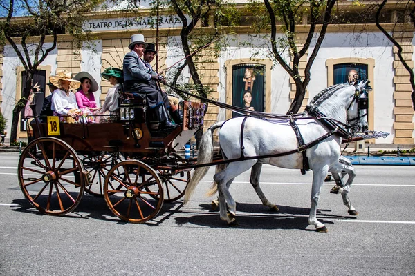 Seville, İspanya... 1 Mayıs 2022 Sevilla 'lılar geleneksel Endülüs tarzında giyinip Seville sokaklarında at arabasıyla geziyorlar.