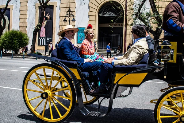 Seville, İspanya... 1 Mayıs 2022 Sevilla 'lılar geleneksel Endülüs tarzında giyinip Seville sokaklarında at arabasıyla geziyorlar.