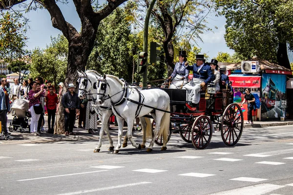 Seville, İspanya... 1 Mayıs 2022 Sevilla 'lılar geleneksel Endülüs tarzında giyinip Seville sokaklarında at arabasıyla geziyorlar.