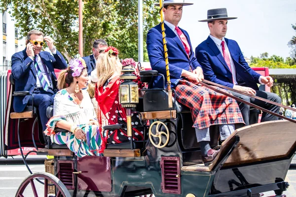 Seville, İspanya... 1 Mayıs 2022 Sevilla 'lılar geleneksel Endülüs tarzında giyinip Seville sokaklarında at arabasıyla geziyorlar.