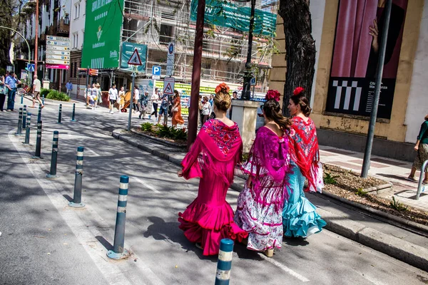 Seville, İspanya - 01 Mayıs 2022 Sevilla sokaklarında yürüyen geleneksel Endülüs tarzı giyinmiş Sevilla halkı iki yıl süren şiddetli bir salgından sonra geri döndü.
