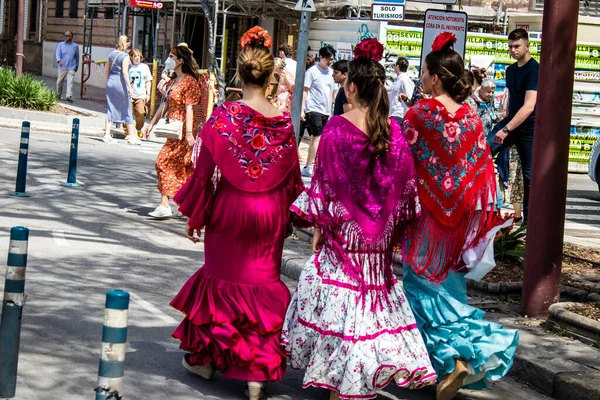 stock image Seville, Spain - May 01, 2022 Sevillians dressed in traditional Andalusian way walking in the streets of Seville, This celebration is back after two years of absence due to covid epidemic