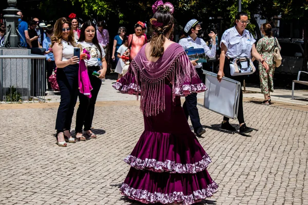Seville, İspanya - 01 Mayıs 2022 Sevilla sokaklarında yürüyen geleneksel Endülüs tarzı giyinmiş Sevilla halkı iki yıl süren şiddetli bir salgından sonra geri döndü.