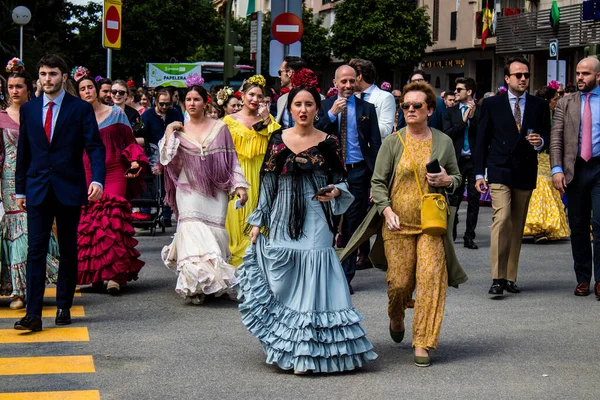 Seville, İspanya - 01 Mayıs 2022 Sevilla sokaklarında yürüyen geleneksel Endülüs tarzı giyinmiş Sevilla halkı iki yıl süren şiddetli bir salgından sonra geri döndü.