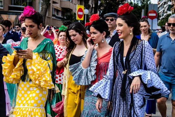 Seville, İspanya - 01 Mayıs 2022 Sevilla sokaklarında yürüyen geleneksel Endülüs tarzı giyinmiş Sevilla halkı iki yıl süren şiddetli bir salgından sonra geri döndü.
