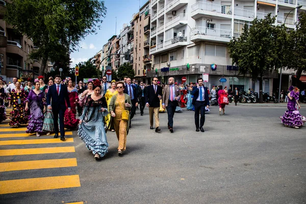 Seville, İspanya - 01 Mayıs 2022 Sevilla sokaklarında yürüyen geleneksel Endülüs tarzı giyinmiş Sevilla halkı iki yıl süren şiddetli bir salgından sonra geri döndü.