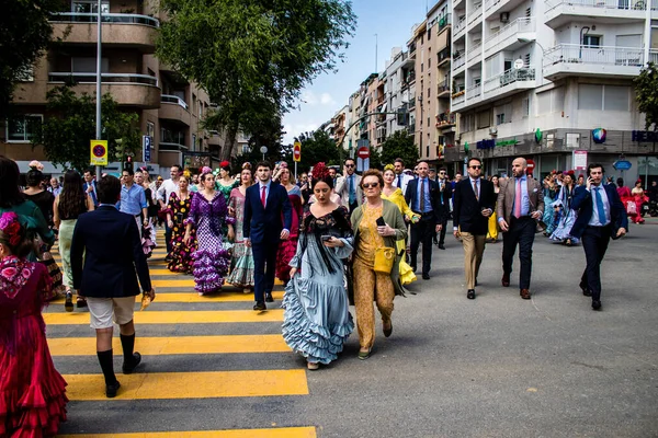 Seville, İspanya - 01 Mayıs 2022 Sevilla sokaklarında yürüyen geleneksel Endülüs tarzı giyinmiş Sevilla halkı iki yıl süren şiddetli bir salgından sonra geri döndü.