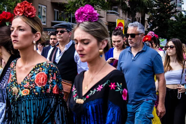 Seville, İspanya - 01 Mayıs 2022 Sevilla sokaklarında yürüyen geleneksel Endülüs tarzı giyinmiş Sevilla halkı iki yıl süren şiddetli bir salgından sonra geri döndü.