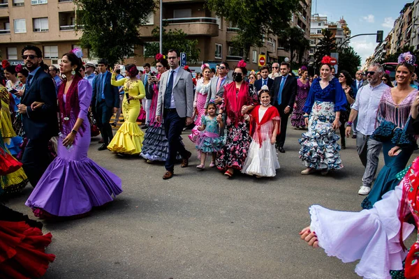 Seville, İspanya - 01 Mayıs 2022 Sevilla sokaklarında yürüyen geleneksel Endülüs tarzı giyinmiş Sevilla halkı iki yıl süren şiddetli bir salgından sonra geri döndü.