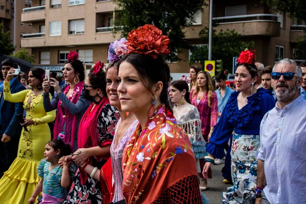 Seville, İspanya - 01 Mayıs 2022 Sevilla sokaklarında yürüyen geleneksel Endülüs tarzı giyinmiş Sevilla halkı iki yıl süren şiddetli bir salgından sonra geri döndü.