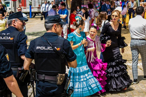 Seville, İspanya - 01 Mayıs 2022 İspanya 'nın en ünlü festivali olan Feria de Sevilla sırasında sokaklara düşen polis memuru, iki yıl süren şiddetli bir salgından sonra kutlamaya geri döndü.