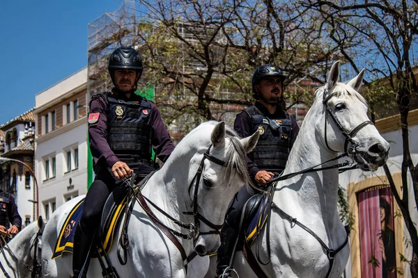 Seville, İspanya - 01 Mayıs 2022 İspanya 'nın en ünlü festivali olan Feria de Sevilla' da atla sokaklarda gezen polis iki yıl süren şiddetli bir salgından sonra kutlamaya geri döndü.