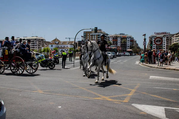 Seville, İspanya - 01 Mayıs 2022 İspanya 'nın en ünlü festivali olan Feria de Sevilla' da atla sokaklarda gezen polis iki yıl süren şiddetli bir salgından sonra kutlamaya geri döndü.