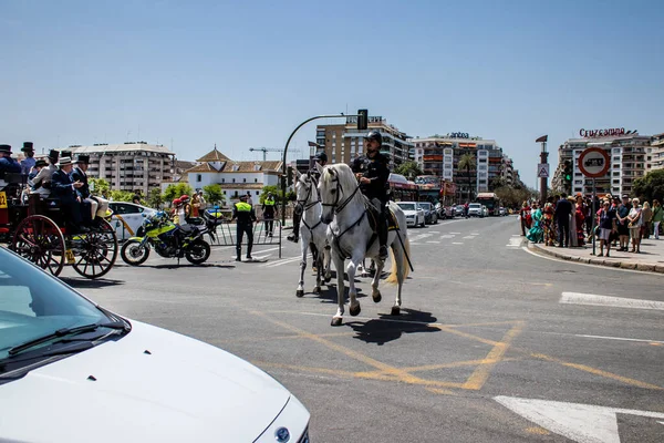 Seville, İspanya - 01 Mayıs 2022 İspanya 'nın en ünlü festivali olan Feria de Sevilla' da atla sokaklarda gezen polis iki yıl süren şiddetli bir salgından sonra kutlamaya geri döndü.