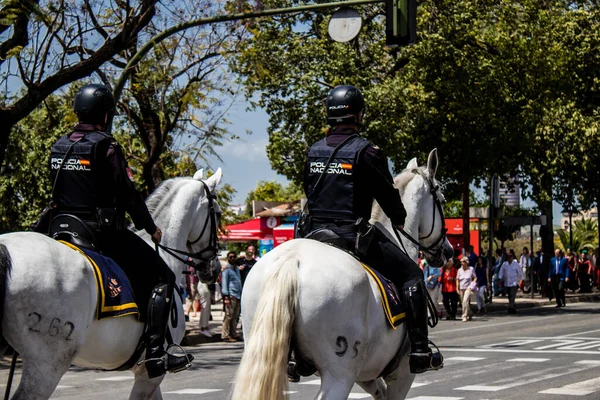 Seville, İspanya - 01 Mayıs 2022 İspanya 'nın en ünlü festivali olan Feria de Sevilla' da atla sokaklarda gezen polis iki yıl süren şiddetli bir salgından sonra kutlamaya geri döndü.