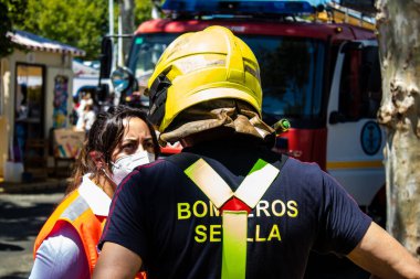 Seville, İspanya - 05 Mayıs 2022 İspanya 'nın en ünlü festivali Feria de Sevilla' ya müdahale eden İtfaiyeci iki yıllık yokluğundan sonra bir salgın nedeniyle geri döndü.