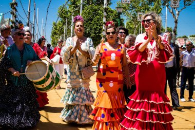 Seville, İspanya - 5 Mayıs 2022 Sevilla 'lılar geleneksel Endülüs tarzında giyinmiş Feria de Seville koridorlarında dolaşıyorlar.