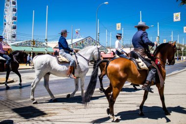 Seville, Spain - May 05, 2022 Sevillian riders dressed in the traditional Andalusian way parading through the aisles of the Feria de Seville, the most famous festival in Spain