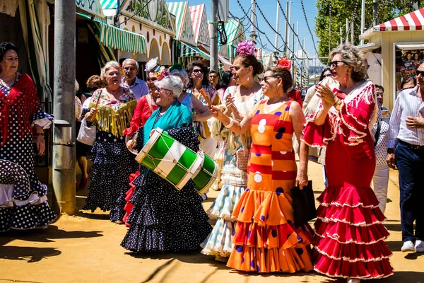 Seville, İspanya - 5 Mayıs 2022 Sevilla 'lılar geleneksel Endülüs tarzında giyinmiş Feria de Seville koridorlarında dolaşıyorlar.
